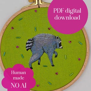 May include: A round wooden embroidery hoop containing lime green fabric with a hand-stitched grey raccoon. The design features scattered pink and green beads. Text on the image reads: PDF digital download and Human made NO AI.
