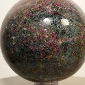 May include: A polished sphere of green and pink ruby in matrix. The sphere is smooth and has a high gloss finish.