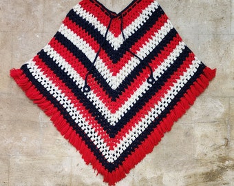 May include: A red, white and blue crocheted poncho with fringe. The poncho has a chevron pattern and is made with a chunky yarn.