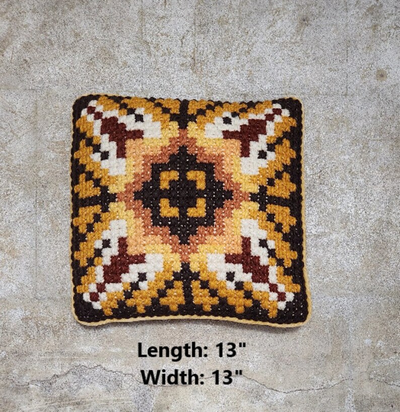 May include: A square-shaped cushion with a geometric pattern in shades of brown, yellow, and white. The cushion measures 13 inches in length and 13 inches in width. "Length: 13" and "Width: 13" are printed below the cushion.
