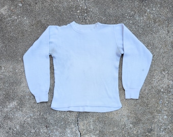 May include: A white long-sleeved thermal shirt with a crew neck.