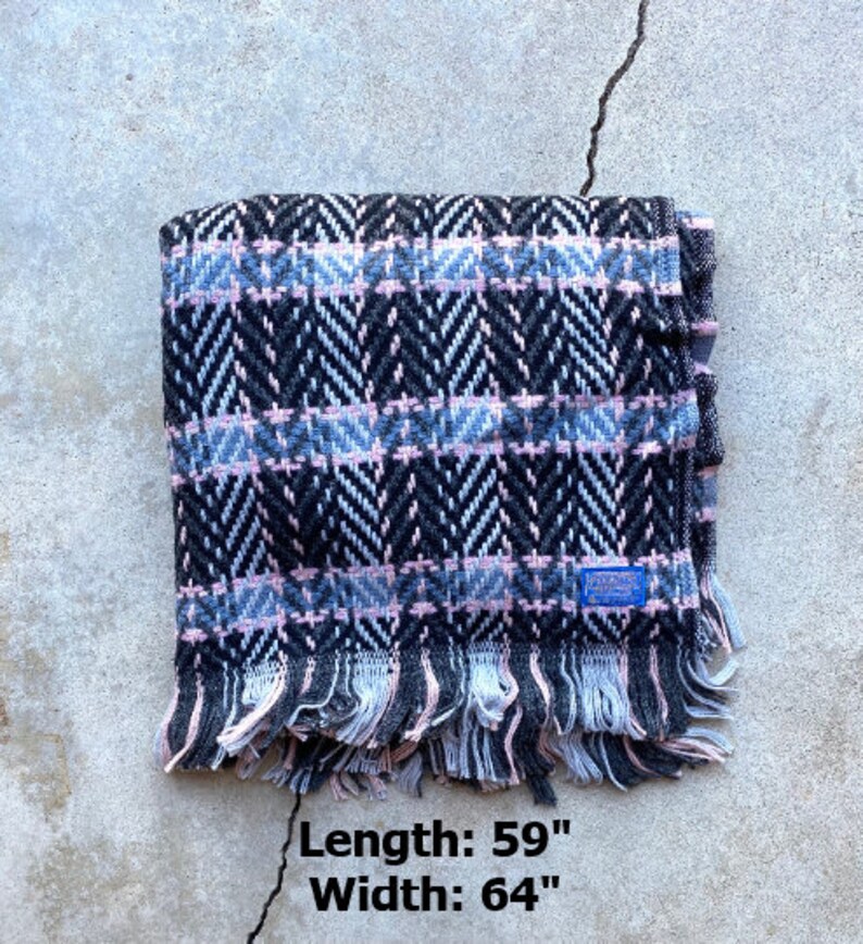 Może przedstawiać: Czarno-r&oacute;żowy pled w wzory z frędzlami na krawędziach. Długość: 59 cali, Szerokość: 64 cali.