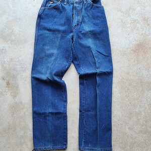 Puede incluir: Un par de pantalones vaqueros de mezclilla azul oscuro con cintura alta y piernas rectas.