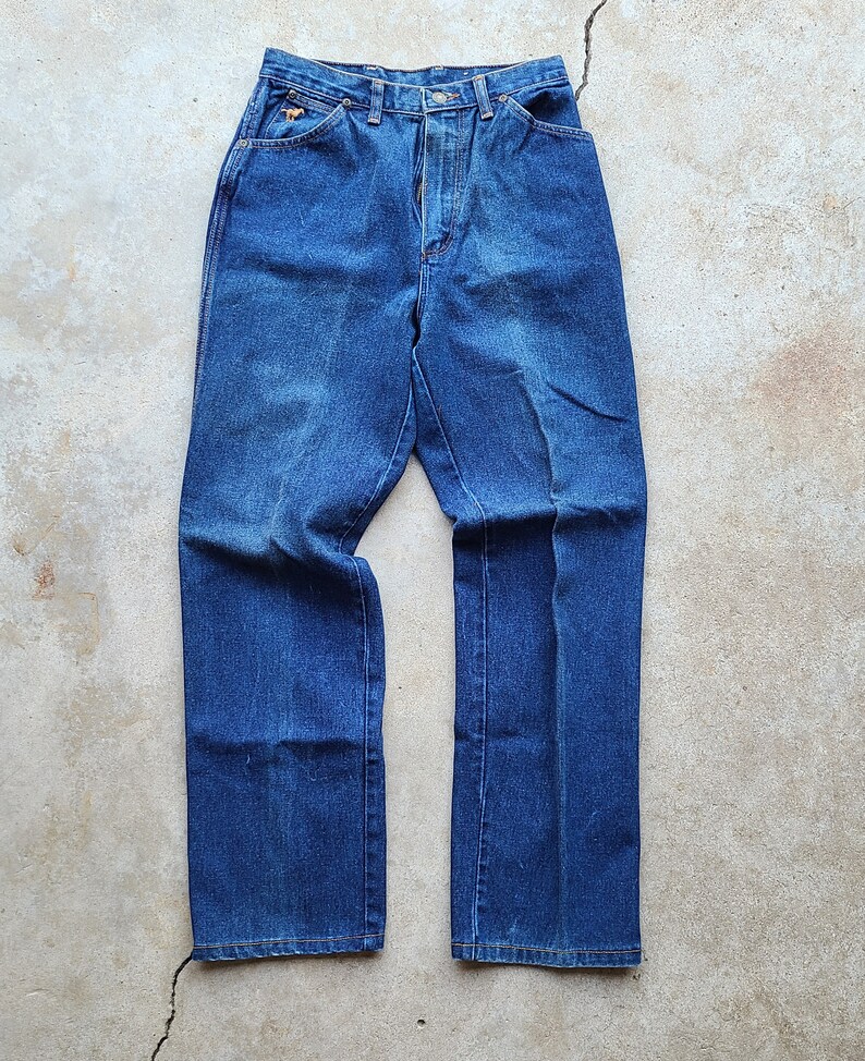 Puede incluir: Un par de pantalones vaqueros de mezclilla azul oscuro con cintura alta y piernas rectas.