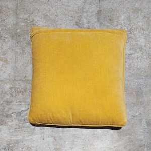 May include: A solid yellow throw pillow with a smooth, slightly textured surface. The pillow is rectangular and has a simple, modern design.