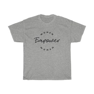 May include: A heather gray t-shirt with the words "Women Empower Women" in black script and a circular font. The shirt is a crew neck style and has short sleeves. The text is centered on the front of the shirt.