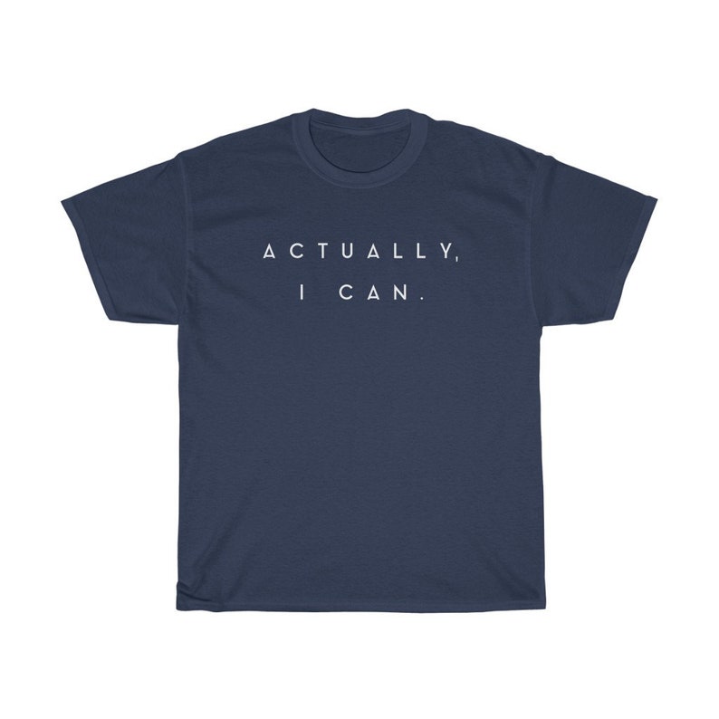 Op de afbeelding: Marineblauwe t-shirt met de witte tekst "ACTUALLY, I CAN." in het midden op de borst. Het shirt heeft korte mouwen en een ronde hals. De stof lijkt zacht en comfortabel.