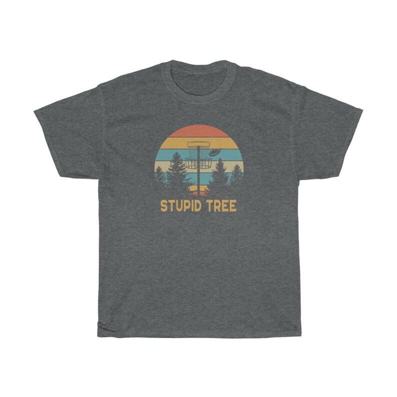 Pode incluir: T-shirt cinzento escuro com um design retro de disc golf. O gr&aacute;fico inclui um cesto de disc golf, &aacute;rvores e um p&ocirc;r do sol. O texto "STUPID TREE" est&aacute; por baixo. Uma t-shirt casual para jogadores de disc golf.