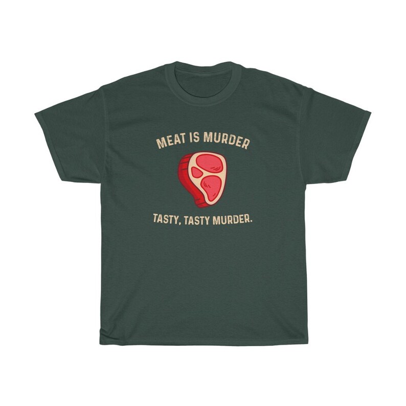 Op de afbeelding: Donkergroen t-shirt met de tekst "MEAT IS MURDER" boven een cartoon steak illustratie. Onder de illustratie staat de tekst "TASTY, TASTY MURDER."