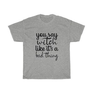 May include: A heather gray t-shirt with the phrase "you say witch like it's a bad thing" in black script. The shirt is a casual, unisex style, perfect for those who embrace the witchy aesthetic.
