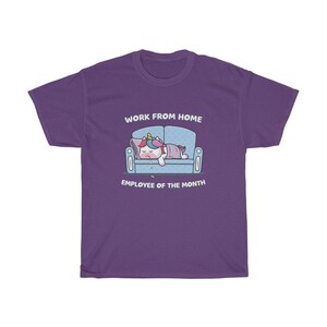 K&ouml;nnte beinhalten: Lilafarbenes T-Shirt mit einer Grafik eines schlafenden Einhorns auf einem blauen Sofa. Der Text "WORK FROM HOME" steht &uuml;ber dem Sofa und "EMPLOYEE OF THE MONTH" darunter.