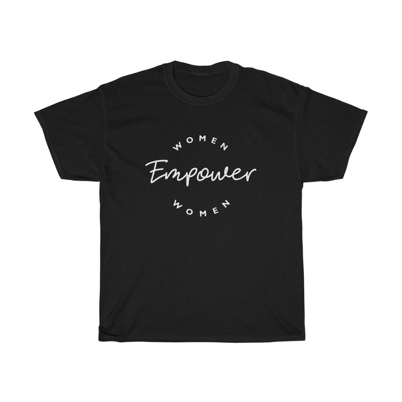 May include: Black t-shirt with the words "Women Empower Women" in a white, circular design. The text is in a handwritten style. The shirt is a crew neck and has short sleeves.
