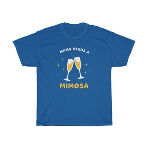 May include: Royal blue t-shirt with the text "MAMA NEEDS A MIMOSA" in white and yellow. The design features two champagne flutes clinking together, with star accents. A casual, comfortable tee.