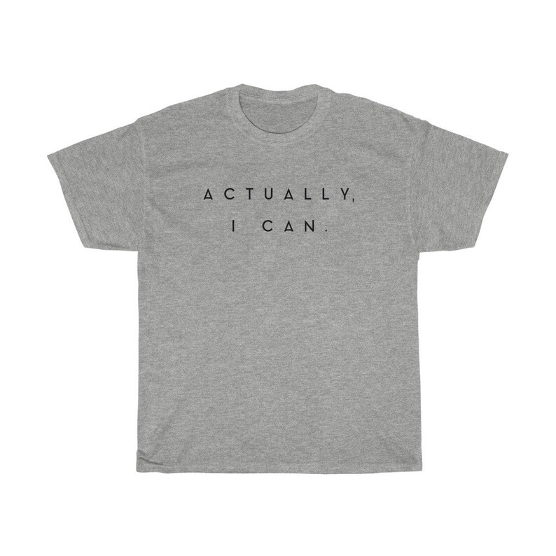 Op de afbeelding: Een grijs t-shirt met de zwarte tekst "ACTUALLY, I CAN.". De top met korte mouwen heeft een ronde hals en is gemaakt van een zachte stof.