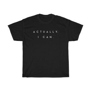 Op de afbeelding: Zwart t-shirt met de witte tekst "ACTUALLY, I CAN." Het shirt heeft een ronde hals en korte mouwen. De tekst staat in het midden op de voorkant van het shirt.