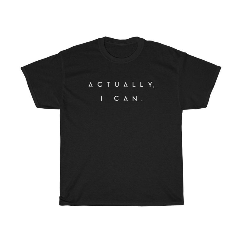Op de afbeelding: Zwart t-shirt met de witte tekst "ACTUALLY, I CAN." Het shirt heeft een ronde hals en korte mouwen. De tekst staat in het midden op de voorkant van het shirt.