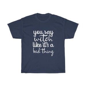 May include: Navy blue t-shirt with the white text "you say witch like it's a bad thing". The shirt is a short-sleeved crew neck style.