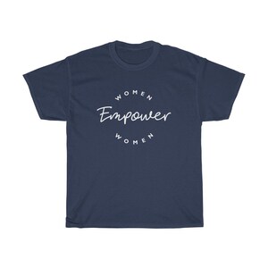 May include: Navy blue t-shirt with the white text "WOMEN Empower WOMEN" in a circular design. The shirt is a crew neck style and made of a soft material. The design is centered on the front of the shirt.