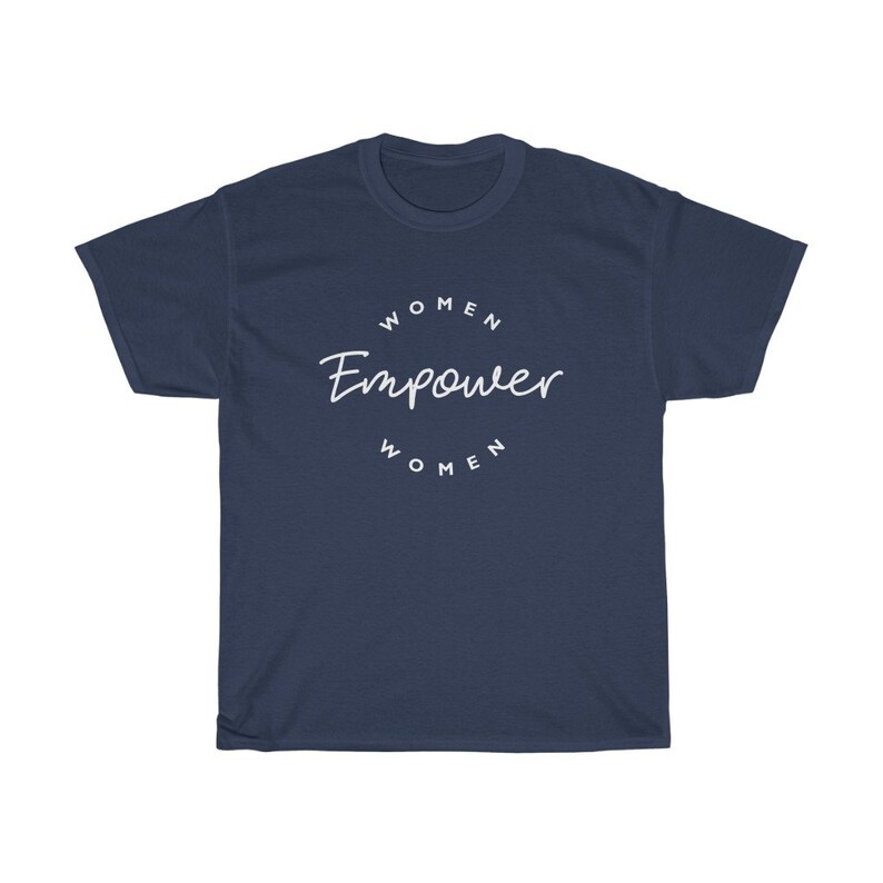 May include: Navy blue t-shirt with the white text "WOMEN Empower WOMEN" in a circular design. The shirt is a crew neck style and made of a soft material. The design is centered on the front of the shirt.
