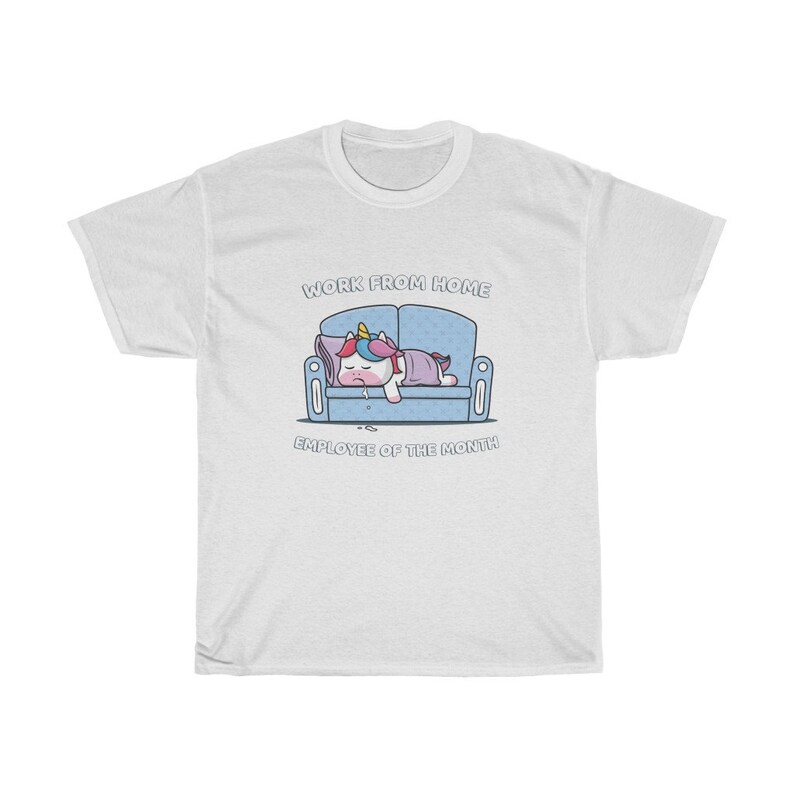 K&ouml;nnte beinhalten: Wei&szlig;es T-Shirt mit einem Cartoon-Einhorn, das auf einem blauen Sofa schl&auml;ft. Der Text "WORK FROM HOME EMPLOYEE OF THE MONTH" befindet sich &uuml;ber und unter der Einhorn-Illustration. Das Shirt besteht aus einem weichen, bequemen Material.