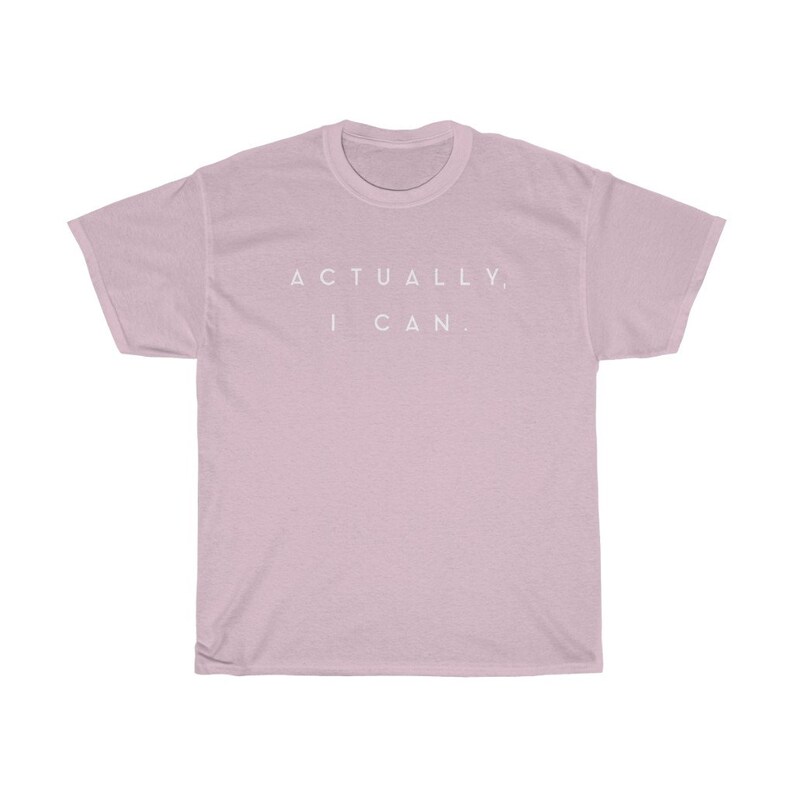 Op de afbeelding: Lichtroze t-shirt met de witte tekst "ACTUALLY, I CAN." gecentreerd op de borst. Het shirt heeft korte mouwen en een ronde hals.