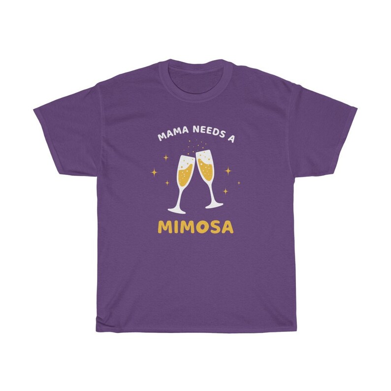 May include: A purple t-shirt with the text "MAMA NEEDS A MIMOSA" in white and yellow. The design features two champagne flutes clinking together, filled with a bubbly drink, and surrounded by small starbursts.