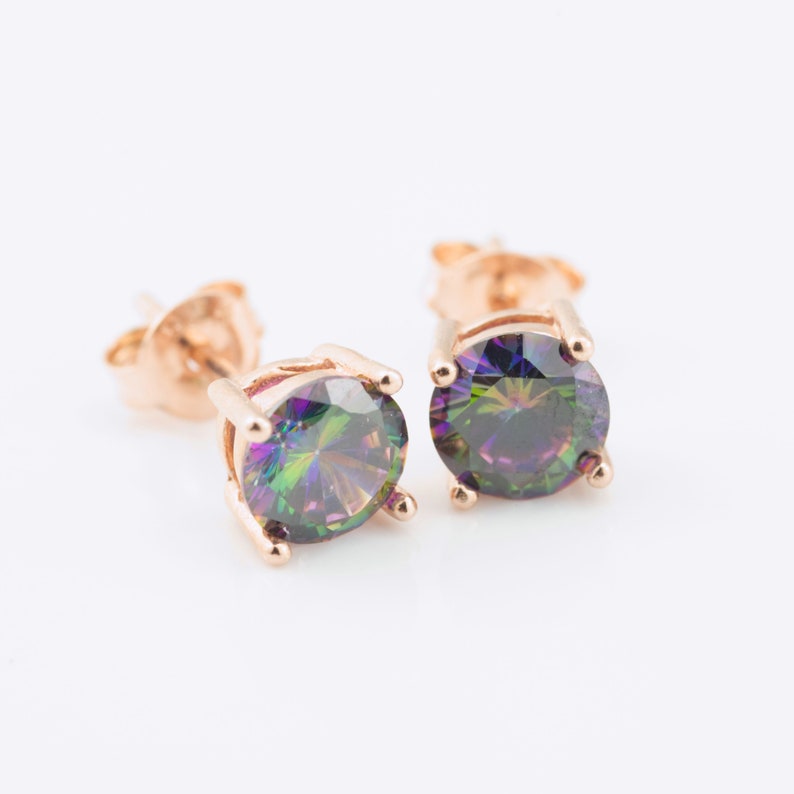 May include: A pair of gold stud earrings with iridescent round gemstones. The gemstones have a rainbow of colours, including green, purple, and blue.