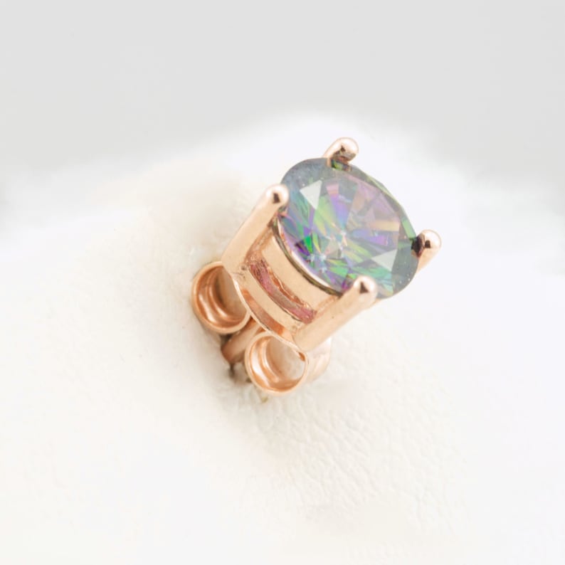 May include: A rose gold earring featuring a round, iridescent gemstone.