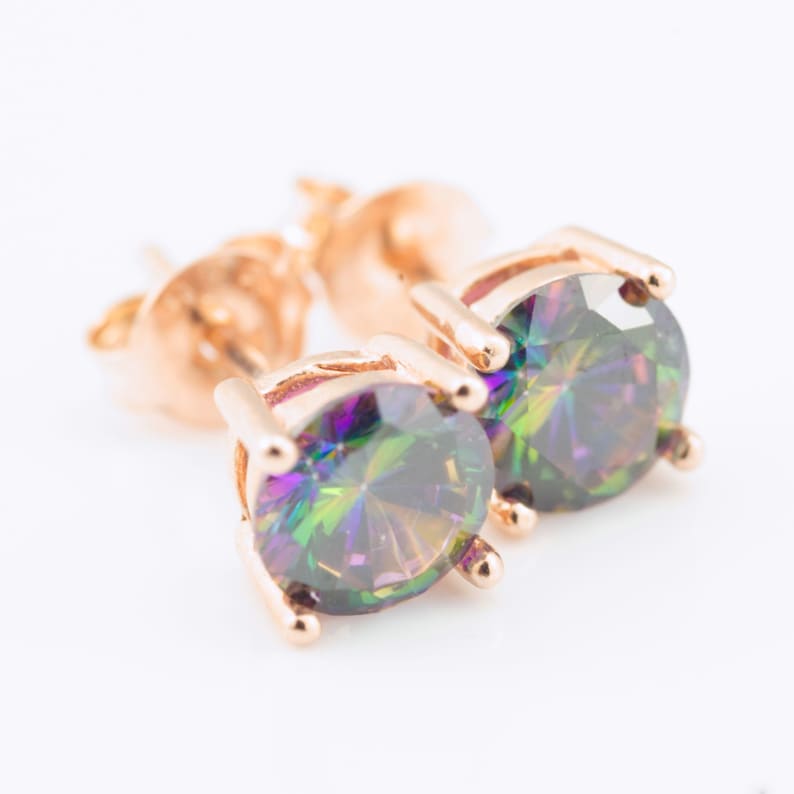 May include: A pair of gold stud earrings with iridescent round gemstones. The gemstones have a rainbow of colours, including green, blue, purple, and red.