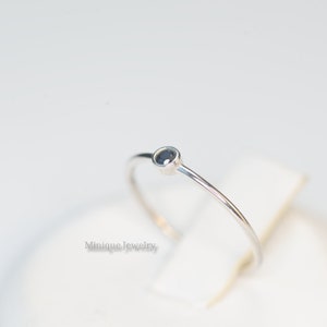 May include: A simple silver ring with a small black gemstone.