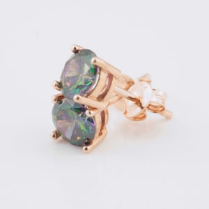 May include: A pair of gold stud earrings with iridescent round gemstones. The earrings have a post and butterfly back.