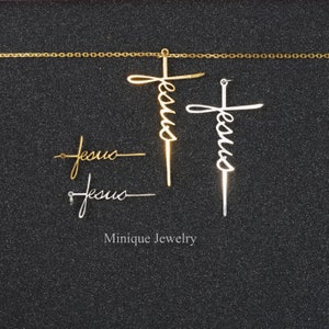 May include: Two gold and silver Jesus cross pendants with a gold chain. The pendants are in the shape of a cross with the word "Jesus" written in cursive.