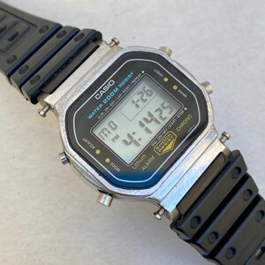 May include: A Casio digital watch with a black and silver rectangular face and a black strap. The watch displays the time and date. The face has the text "CASIO WATER 200M RESIST".