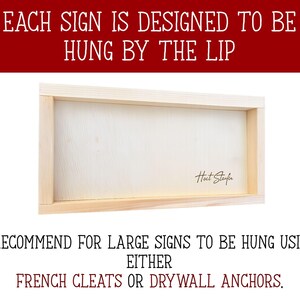 May include: A rectangular wooden sign with a light-colored wood frame. The sign's text reads "EACH SIGN IS DESIGNED TO BE HUNG BY THE LIP." Below the sign, the text reads "I RECOMMEND FOR LARGE SIGNS TO BE HUNG USING EITHER FRENCH CLEATS OR DRYWALL ANCHORS."