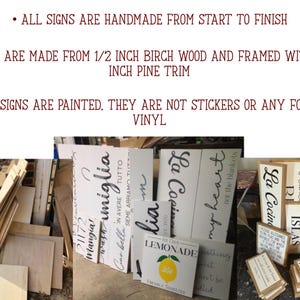 May include: A collection of handmade wooden signs with various phrases and designs. The signs are painted and framed with pine trim. Some signs feature text like "La Cocina" and "Lemonade".