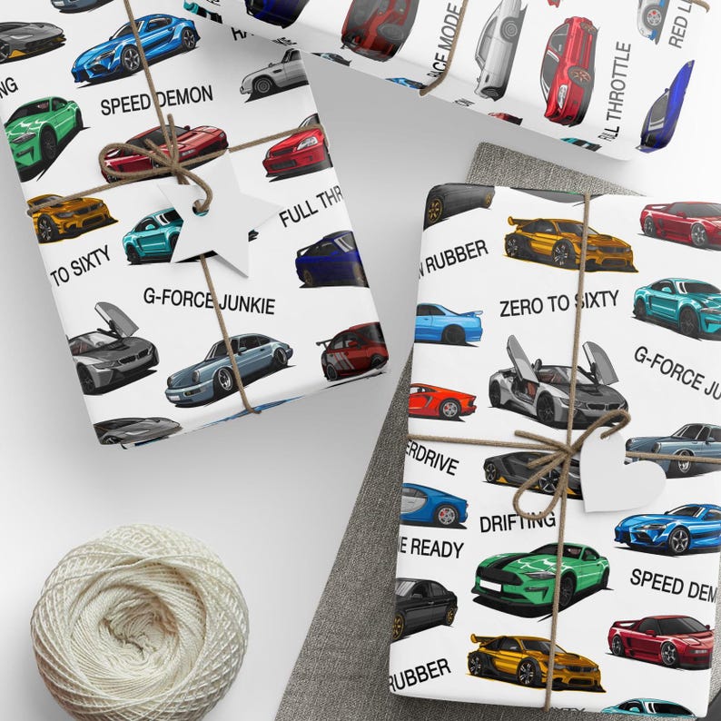 a pair of scissors next to wrapping paper with cars on it
