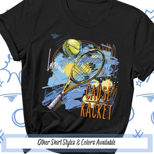 May include: Black t-shirt with a colorful graphic of a tennis racket and ball. The text "Cause a Racket" is written in orange on the shirt.