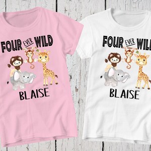 May include: Two short-sleeve t-shirts, one light pink and one white, each featuring a graphic of a lion, monkey, elephant, and giraffe. The text "FOUR EVER WILD" appears above the animals, and the name "BLAISE" is printed in black below them.