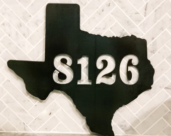 May include: Black metal cutout of the state of Texas with the number 8126 cut out in the center.