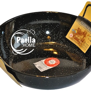 May include: Black enamel paella pan with white speckles. The pan has two yellow handles and a label that says "Esmaltada" and "Paella Home".