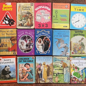 May include: A collection of vintage Ladybird books with colorful covers. Titles include "Home Safety," "Aesop's Fables," "Multiplication," "Royal Wedding," and "A Christmas Carol." The books are arranged on a flat surface.