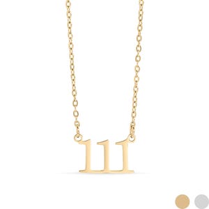 Op de afbeelding: Een goudkleurige ketting met een hanger met het nummer 111. De hanger heeft een minimalistisch ontwerp. De ketting is delicaat en bestaat uit kleine, verbonden schakels. De ketting wordt tegen een witte achtergrond getoond.