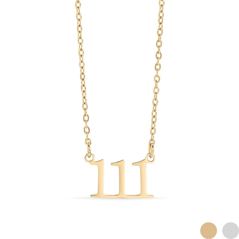 Op de afbeelding: Een goudkleurige ketting met een hanger met het nummer 111. De hanger heeft een minimalistisch ontwerp. De ketting is delicaat en bestaat uit kleine, verbonden schakels. De ketting wordt tegen een witte achtergrond getoond.