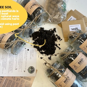 May include: Six glass jars filled with peat-free soil, labelled with different herbs: Chives, Parsley, Basil, Coriander, and Mint. Each jar is tied with twine and includes a small brown paper bag with seeds. The image includes a yellow sign that reads "PEAT FREE SOIL" and a message about protecting peatlands.