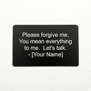 May include: A black rectangular sign with rounded corners. White text reads: "Please forgive me. You mean everything to me. Let's talk. - [Your Name]" The sign is centered on a white background.