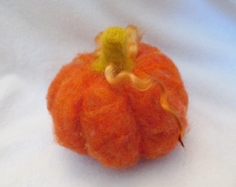 May include: A handmade orange felt pumpkin with a yellow stem and curly tendrils. The pumpkin is a vibrant orange color and has a textured surface. This decorative item is perfect for fall and autumn-themed decor.