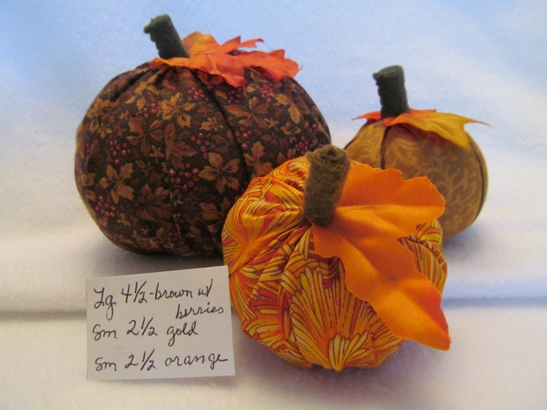 A Set of Three Fabric Pumpkins for the Autumn One Bright Orange Pumpkin One Gold on Gold Pumpkin One Large Brown with Berries Pumpkin