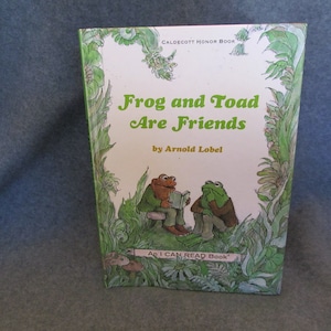 May include: A hardcover book titled "Frog and Toad Are Friends" by Arnold Lobel. The cover features illustrations of a frog and toad, with green and brown tones. The book is part of the "An I CAN READ Book" series.