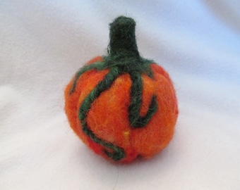 May include: A handmade, orange felt pumpkin with green vines and stem. The pumpkin is round and textured, perfect for fall decor. The green vines wrap around the orange pumpkin, adding a touch of detail.