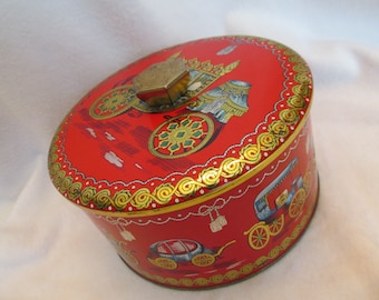 May include: Red round tin with a gold lid and a gold trim. The tin has a design of a horse-drawn carriage with a red and gold canopy. The tin is about 4 inches in diameter.